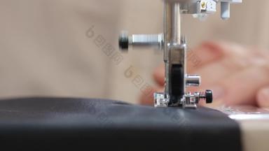 特写镜头拍摄男性手推材料缝纫机使修复西装改变卷边手工制作的服装